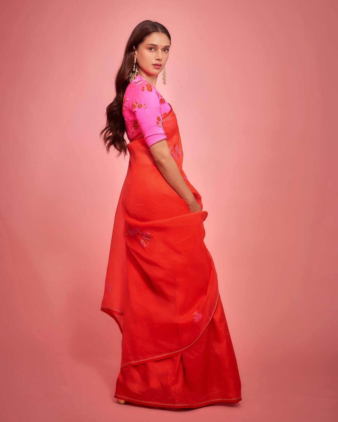 Aditi Rao Hydari dazzled in a bright orange saree featuring pink floral work. She paired the drape with a deep pink blouse, giving out an elegant appeal.